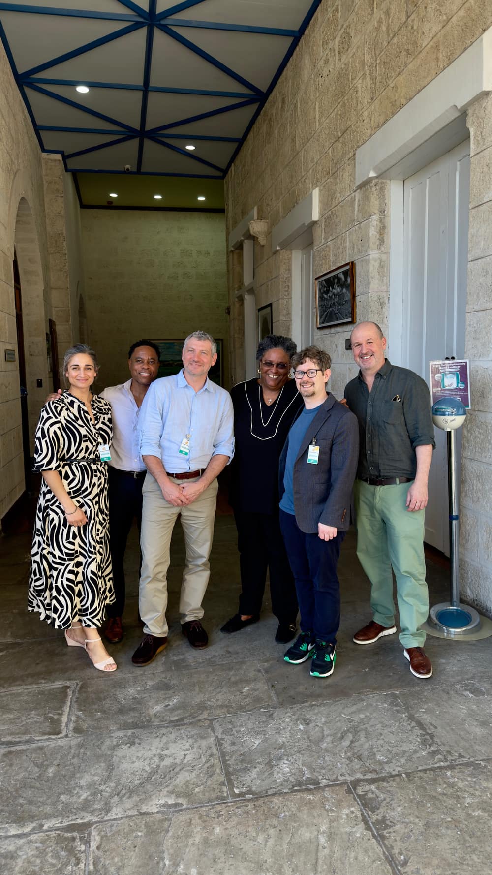 The Public Digital team with the Prime Minister of Barbados, standing together in a stone-walled entrance hall.